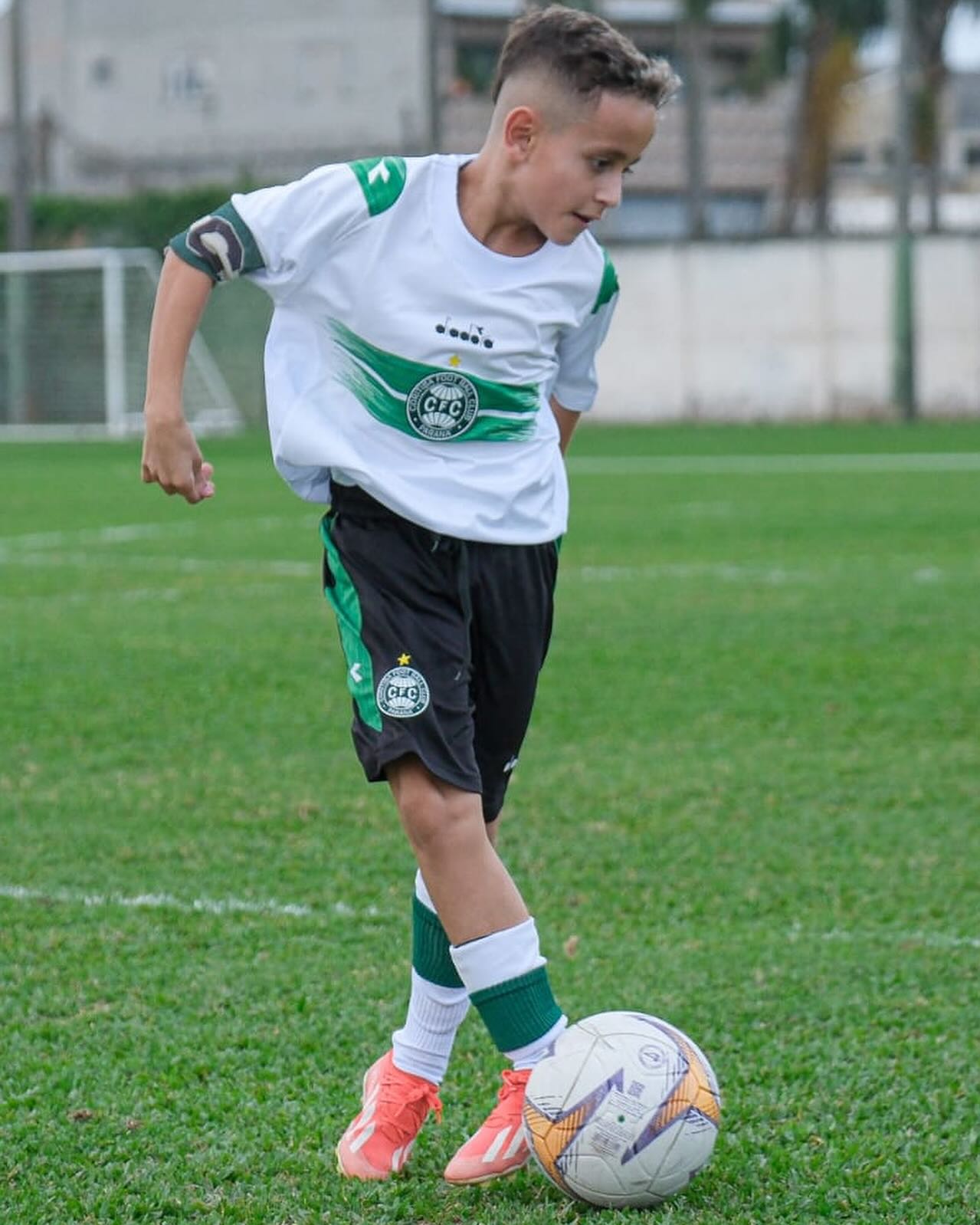 Aluno do Sub-11 conduzindo a bola em jogo